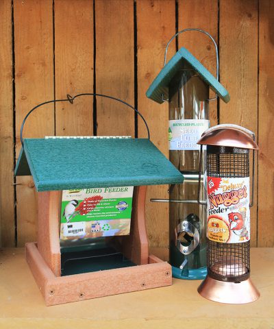 Keep Wild Birds Around this Winter - Three bird feeders. The first is a double-sided feeder with a green roof. The second is a green-roofed tube feeder. The third is a brass feeder with a mesh tube for large seed.